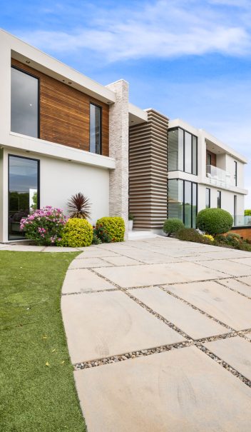 A Driveway of a contemporary house with a garden area